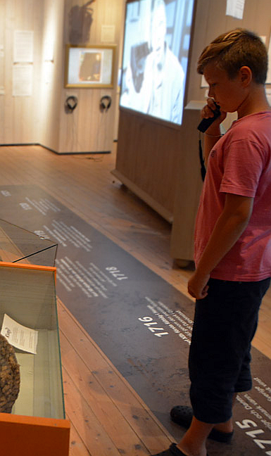 Besökare på Bohusläns museum som lyssnar med Okayo audioguide i tillfällig utställning. Foto: musedia